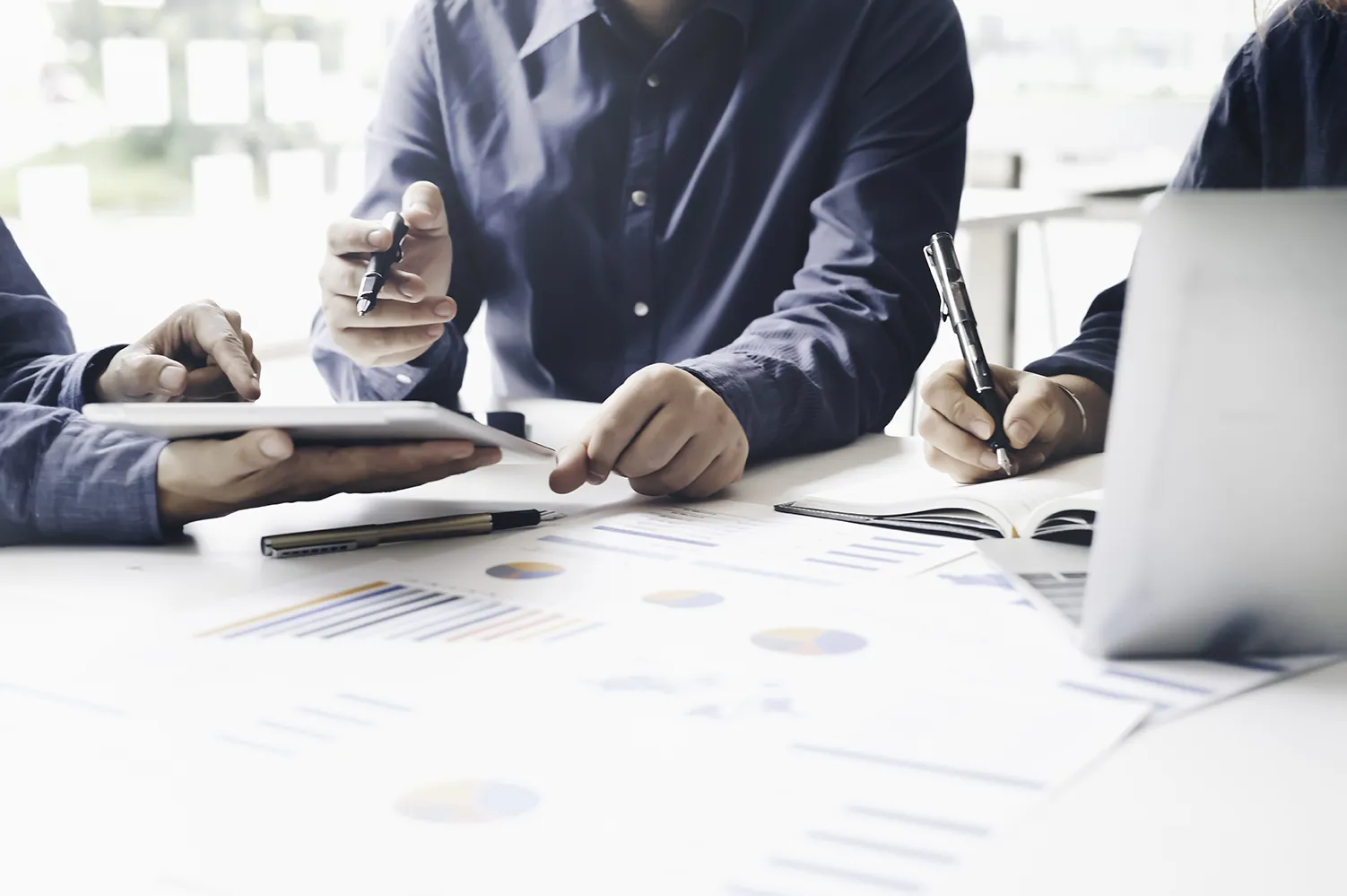 Treffen asiatischer Unternehmensberater zur Analyse und Diskussion der Situation im Finanzbericht im Besprechungsraum.
